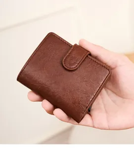 Détail de la texture en cuir marron foncé et du bouton-pression d'un portefeuille RFID
