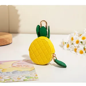 Détail du porte-monnaie ananas jaune avec fermeture feuille et fermoir doré