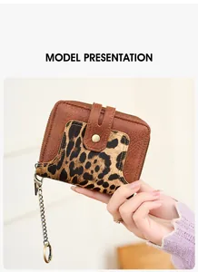 Detail of short leather wallet with leopard print pattern and metal key chain