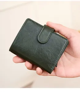 Gros plan d'un portefeuille RFID en cuir vert avec texture grainée et boucle de fermeture