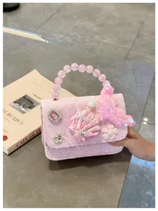 Dettaglio della borsa rosa da bambina con pizzo, perle e decorazioni a conchiglia
