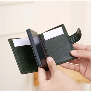 Gros plan du porte-cartes RFID en cuir vert foncé avec mécanisme pop-up en aluminium