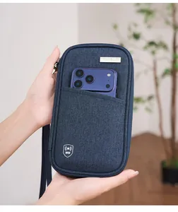 Close-up of waterproof RFID passport bag in blue fabric holding a purple smartphone