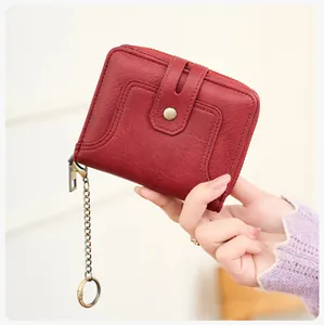 Detail of a dark red vintage leather wallet with gold chain and RFID blocking function
