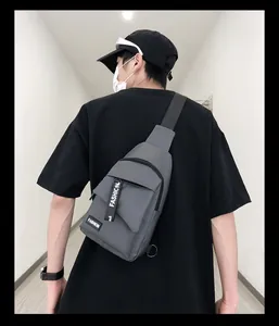 Detail of adjustable black nylon shoulder strap and buckle on grey men's sports chest bag