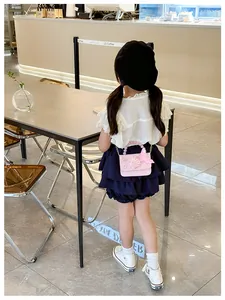 Dettaglio borsa rosa per bambina con manico di perle, farfalla 3D e tracolla a catena