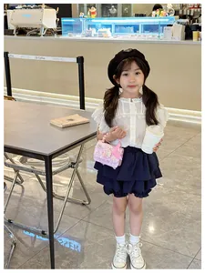 Mini borsa rosa da bambina con decorazioni floreali e perle in un outfit alla moda