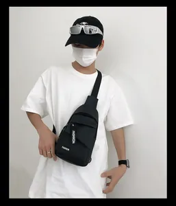 Detail of black nylon chest bag with white Fashion print on street style model