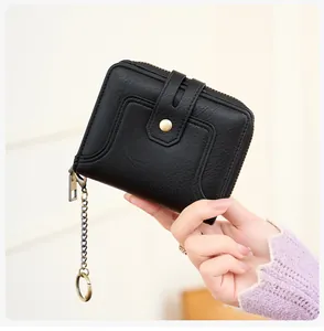 Close-up of black pebble leather wallet featuring metal zipper and keychain chain details