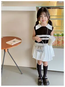 Chic girl outfit with sleeveless top, pleated skirt, and silver bow crossbody bag