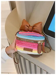 Macro shot of colorful woven mini bag with large brown bow and gold chain strap