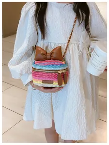 Close-up of rainbow woven kids crossbody bag with leather bow and chain strap