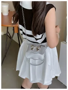 Close-up of metallic silver PU mini bag featuring a metal bow and elegant wavy flap