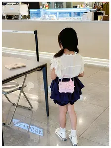 Mini borsa a tracolla rosa con paillettes e farfalla 3D su un outfit da bambina