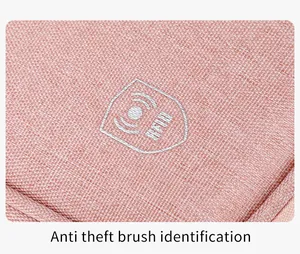 Detail of light pink waterproof fabric and white RFID blocking logo on travel pouch