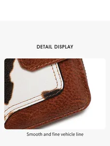 Detailed close-up showing fine stitching and cow print leather texture on the wallet
