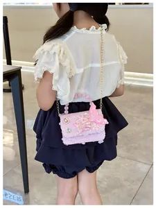 Dettaglio borsa rosa con paillettes per bambina con perle e farfalla 3D sulla bambina