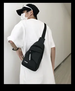 Detail of the durable black nylon chest bag with white FASHION lettering and zippers