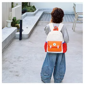 Close-up detail of a colorful toddler backpack with contrast pockets and side water bottle holder