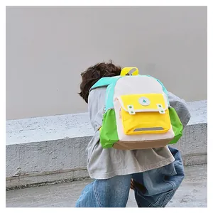 Outdoor shot of kid backpack with yellow front pocket and green side water bottle holder