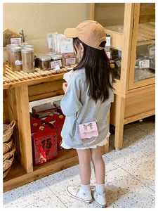 Close-up of pink PU leather girls crossbody bag with metal bow and wavy trim detail
