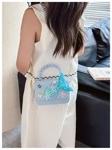 Vista dettagliata di una bambina con borsa a tema sirena in pizzo e manico di perle