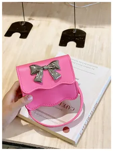 Detail of bright pink PU mini handbag with wavy edge and silver metal bow decoration