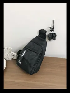Detail of black camo nylon chest bag with Fashion label on a wooden table setup