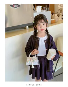 Detail of girl holding a floral handbag with pearl handle, embroidery, and tassel accents