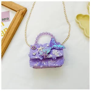 Dettaglio borsa a sirena con paillettes viola, manico di perle e catena d'oro da bimba