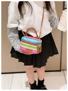 Rainbow woven crossbody bag with brown leather handles and golden chain strap detail