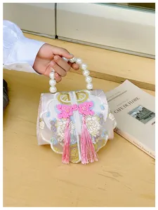 Detailed view of pearl handle and floral embroidery on traditional Chinese style bag