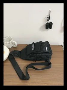 Detail view of black camouflage nylon chest bag with fashion print and adjustable strap
