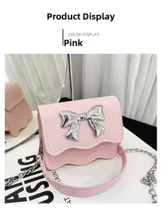 Detail of pink PU crossbody bag with large metallic bow and elegant stitching