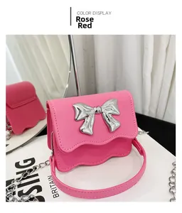 Detail of rose red PU mini handbag with silver metal bow and wavy edge design