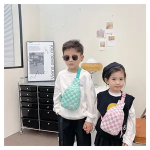 Close-up of kids checkerboard chest bags in mint green and pink with fashion labels