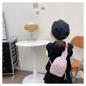 Back view of a girl wearing a pink checkered quilted chest bag with adjustable strap