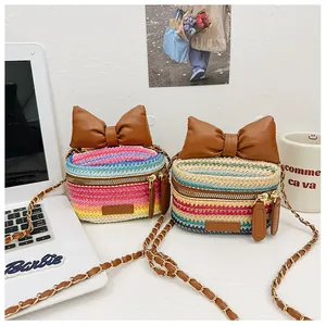 Detail of mini woven crossbody bags featuring rainbow stripes and large bow decorations