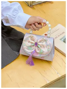 Detail of a purple princess handbag with mesh bow, pearl handle and silk tassels