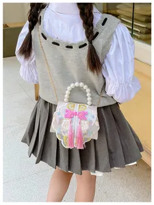 Girl's Chinese style embroidered bag with large pearl handle and pink tassels details
