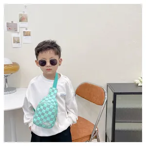 Close-up of mint green checkered kids chest bag with fashion label and textured fabric