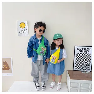 Kids wearing bright green and yellow cartoon bear crossbody bags in a stylish lifestyle setting