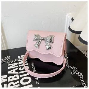 Detail of light pink PU leather mini bag with silver bow and wavy edge flap