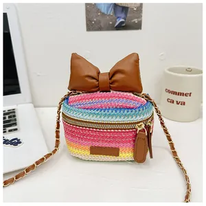 Macro shot of mini woven bucket bag with leather bow and golden chain strap detail