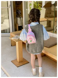 Pink striped toddler chest bag with tulip charm worn by a child in outdoor cafe