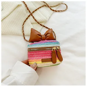 Close-up of colorful woven mini bag with large brown bow and metallic double zipper