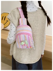 Close-up of pink and yellow striped kids chest bag with adjustable strap and floral charm