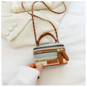 Close-up of a gradient woven crossbody bag featuring a leather handle and metal chain strap