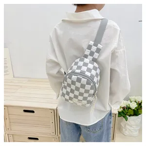 Detailed close-up of kids checkerboard chest bag featuring FASHION label and zip closure