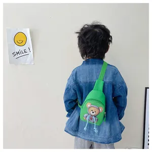 Detail of bright green cartoon bear chest bag worn by a child for outdoor sports